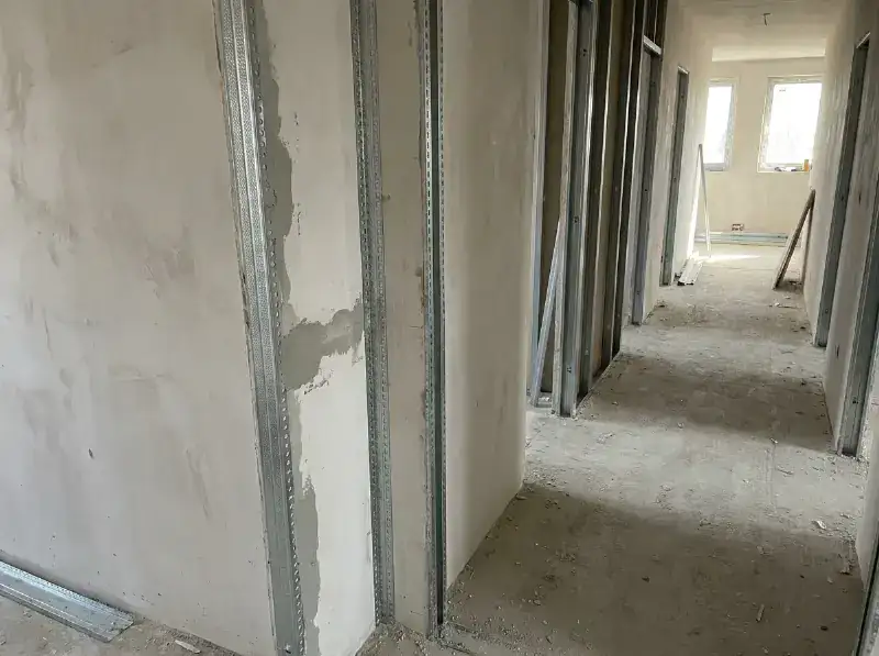 Reeks verzinkte hoekprofielen gezet op de buitenhoeken van een gang in aanbouw